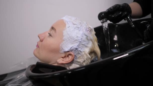 Processo di lavaggio dei capelli in un parrucchiere. Ragazza in un salone di bellezza . — Video Stock