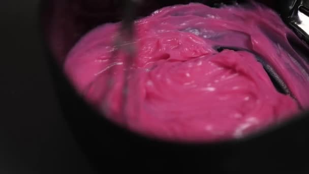 De kapper mengt roze haarverf in een zwarte schaal. — Stockvideo