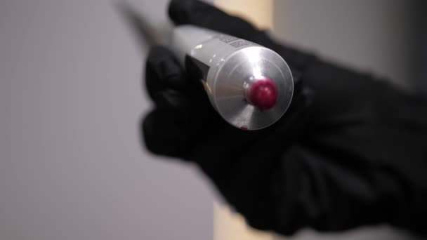 Ένας κομμωτής συμπιέζει ροζ βαφή μαλλιών από ένα σωλήνα σε κοντινό πλάνο.4k — Αρχείο Βίντεο