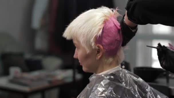 Close-up of stylist hands using professional hairbrush and dyeing hair roots — Stockvideo