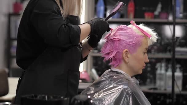 Mani stilista utilizzando spazzola per capelli professionale e tintura radici dei capelli — Video Stock