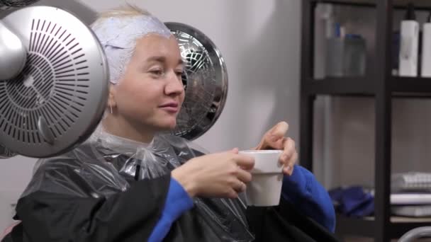 A girl in a beauty salon for a hair coloring procedure. 4K — Stockvideo
