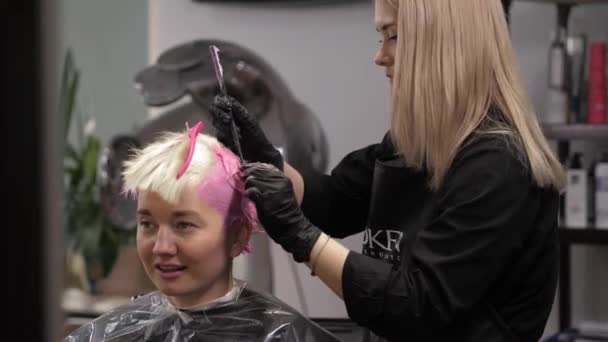 Stylist hands using professional hairbrush and dyeing hair roots — Stockvideo