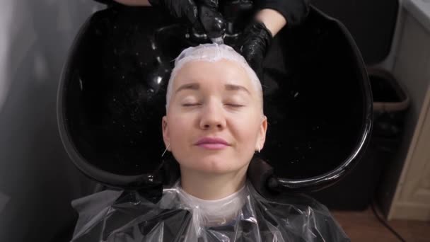 Proceso de lavarse el cabello en una peluquería. Chica en un salón de belleza . — Vídeos de Stock