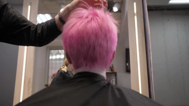 El pelo corto de color rosa se seca por soplado en una peluquería. Vista trasera desde abajo. Movimiento lento — Vídeos de Stock