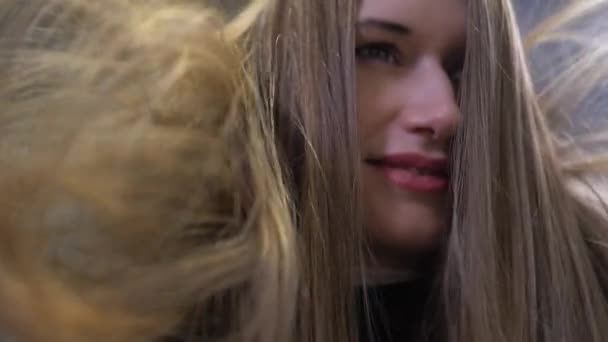 Девушка улыбается в камеру, пока ее волосы высушивают в салоне — стоковое видео
