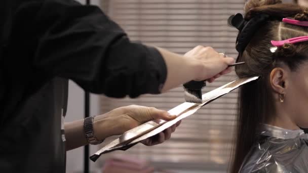 Cute girl w salonie piękności na procedurze farbowania włosów. Samolot — Wideo stockowe