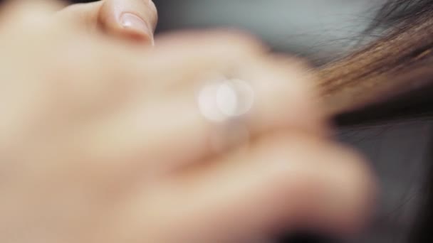 Hairdresser at salon combing hair comb girl brunette. 4K Close up — Αρχείο Βίντεο