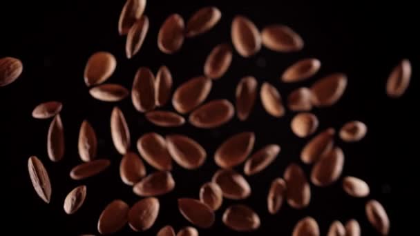 Almonds fly up and down on a black background.Cooking healthy food with almonds. — Stock Video