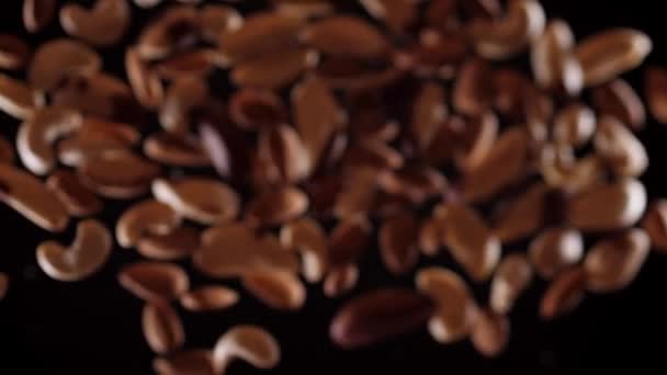 坚果的混合物在黑色的背景上上下飞舞.用坚果拌匀烹调健康食品 — 图库视频影像