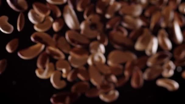 Горіхова суміш літає вгору і вниз на чорному тлі. Приготування здорової їжі з горіховою сумішшю — стокове відео