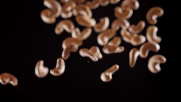 Cashew fly up and down on a black background. Cooking healthy food with cashew — Stock Video