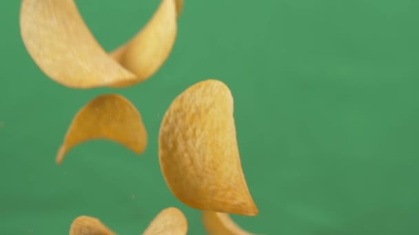 Batatas fritas em queda livre em um fundo verde. Movimento lento. Pringles — Vídeo de Stock