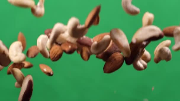 Nut mix fly up and down on a green background. Cooking healthy food with nut mix — Stock Video