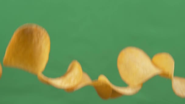 Batatas fritas em queda livre em um fundo verde. Movimento lento. Pringles — Vídeo de Stock