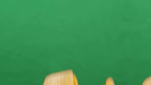 Brambůrky ve volném pádu na zeleném pozadí. Zpomal. Pringles — Stock video