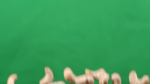 カシューは緑の背景で上下に飛ぶ。カシューナッツでヘルシーな料理 — ストック動画