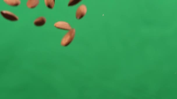 アーモンドは緑の背景で上下に飛ぶ.アーモンドと健康食品を調理. — ストック動画
