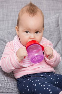Holding ve oturan kırmızı plastik su şişesi emme bebek kız 