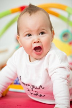 Sekiz aylık bebek kız bir yere renkli oyuncaklar ile oynama