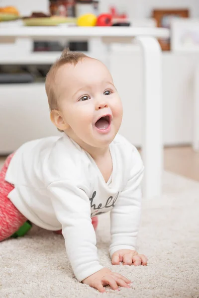 Niña de nueve meses jugando a arrastrarse en la alfombra del piso — Foto de Stock