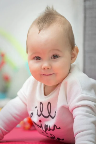 Niña de ocho meses acostada sobre su vientre en la alfombra del piso , — Foto de Stock