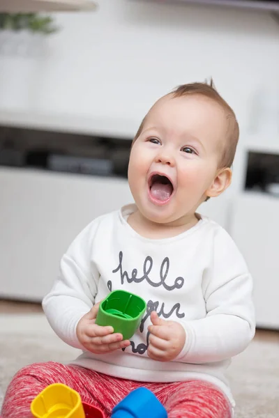 Kilenc hónapos baba lány játszik vele a játékokat, az emeleten — Stock Fotó