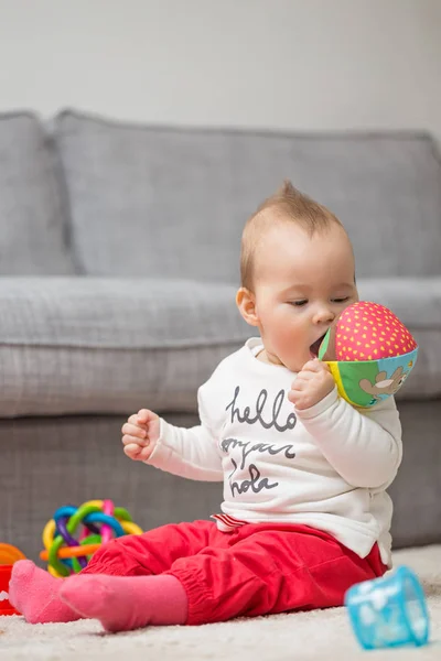 Acht Monate altes Mädchen sitzt auf dem Boden und spielt mit ihr — Stockfoto