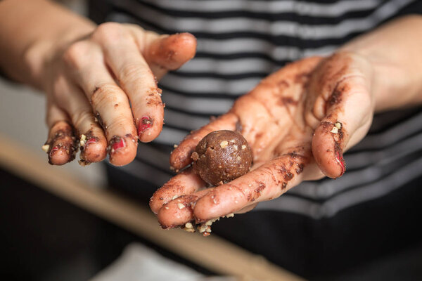 Woman rolling homemade chocolate truffles in her hands