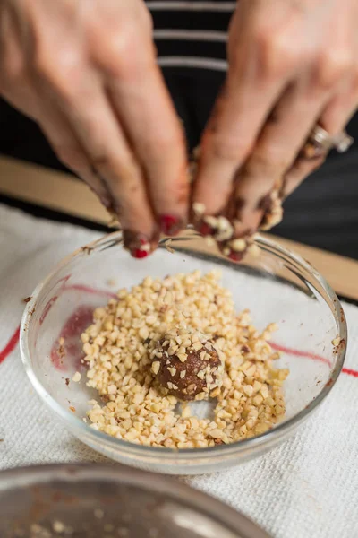 Kadın ona teslim ev yapımı çikolata truffles haddeleme — Stok fotoğraf