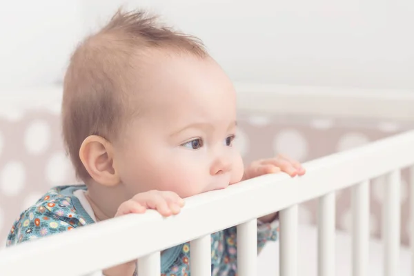 Acht Monate altes Mädchen lutscht die Seite ihres Bettes — Stockfoto