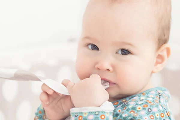 Acht Monate altes Mädchen saugt den Stoff aus ihrem Bett — Stockfoto