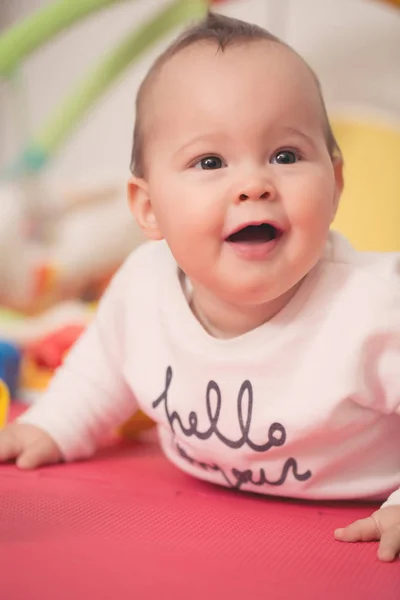 Huit mois bébé fille jouer avec des jouets colorés sur un plancher — Photo