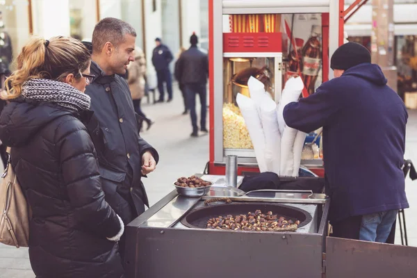 客户从萨格勒布市中心街头小贩购买烤的栗子 — 图库照片