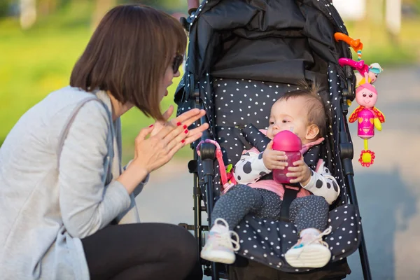 Mère communiquant avec son bébé fille d'un an Image En Vente