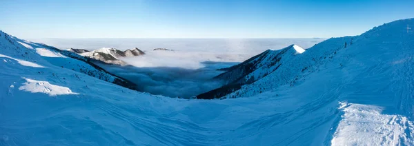 Panorama desde la cresta de montaña de invierno por encima de las nubes bajas —  Fotos de Stock