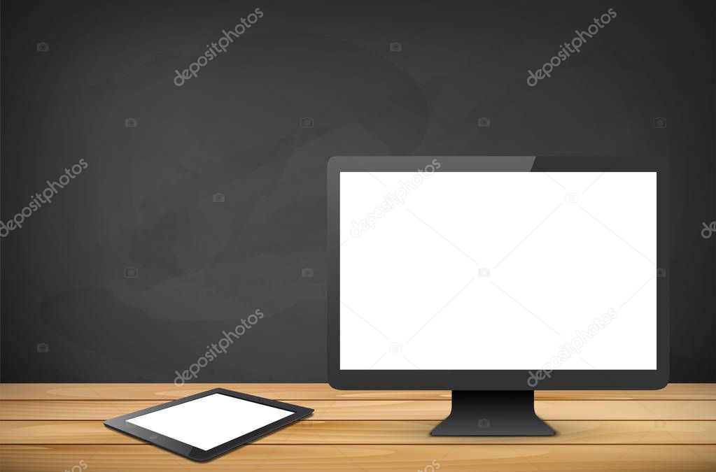 Computer and tablet with blank screen on wooden tabletop