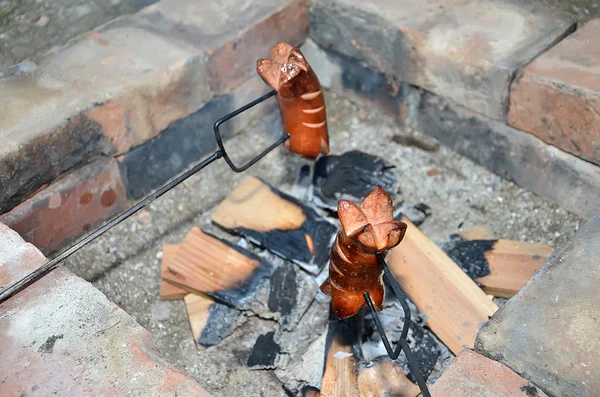 Two grilling sausages over a fire in summer — Stock Photo, Image