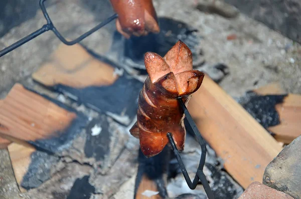 Detalhe de grelhar salsicha sobre um fogo no verão — Fotografia de Stock