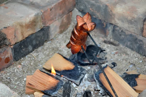 One grilling sausage over a fire in summer — Stock Photo, Image