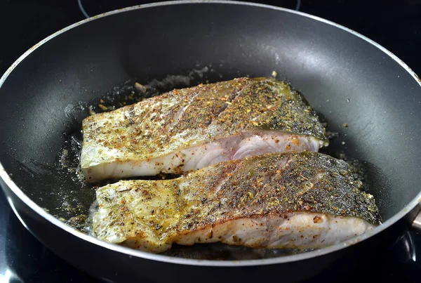 Freír pescado con especias en la cocina de sartén caliente fotografía —  Fotos de Stock