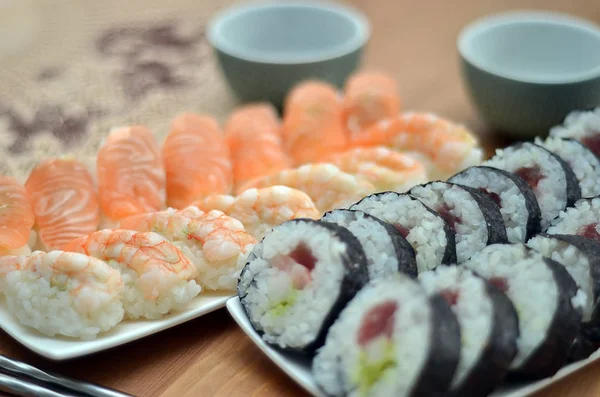 Detail van de maki sushi rolt en nigiri sushi met zalm en garnalen japan voedsel op tafel — Stockfoto