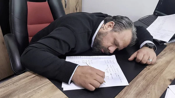 Ofiste çalışırken uyuyakalan bir iş adamı.