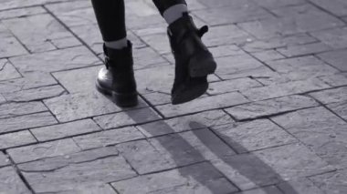 Asfalt yolda yürüyen bir kadın.