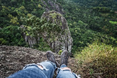 Bir dağın kıyısında duran bir adamın ayakları