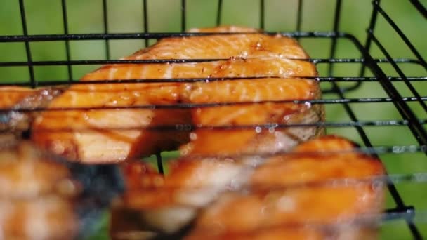 Filetes de trucha dorada horneados freír a la parrilla de carbón. Pescado rojo salmón en barbacoa . — Vídeo de stock