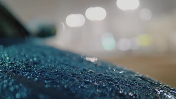 Lluvia con nieve cae sobre capucha azul azur del coche, gotas de lluvia goteando en la superficie — Vídeo de stock