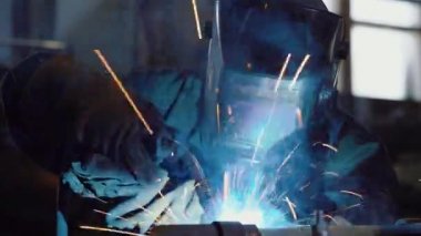 Koruyucu maskeli işçiler, metal parçalarının dikişlerini bağlamak için gaz kaynağı kullanıyor