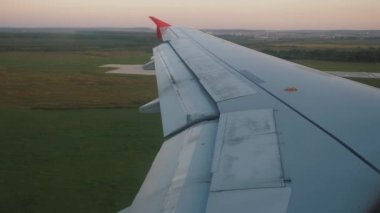 Jet uçağı havaalanına iniyor. Uçağın penceresinden kanada bak.