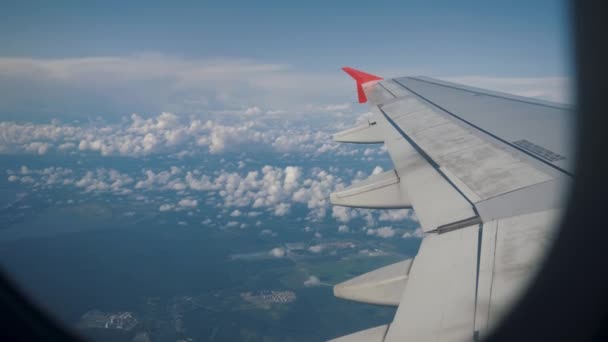 Flygplansvingen flyger ovanför molnen. Utsikt från fönstret på planet. — Stockvideo